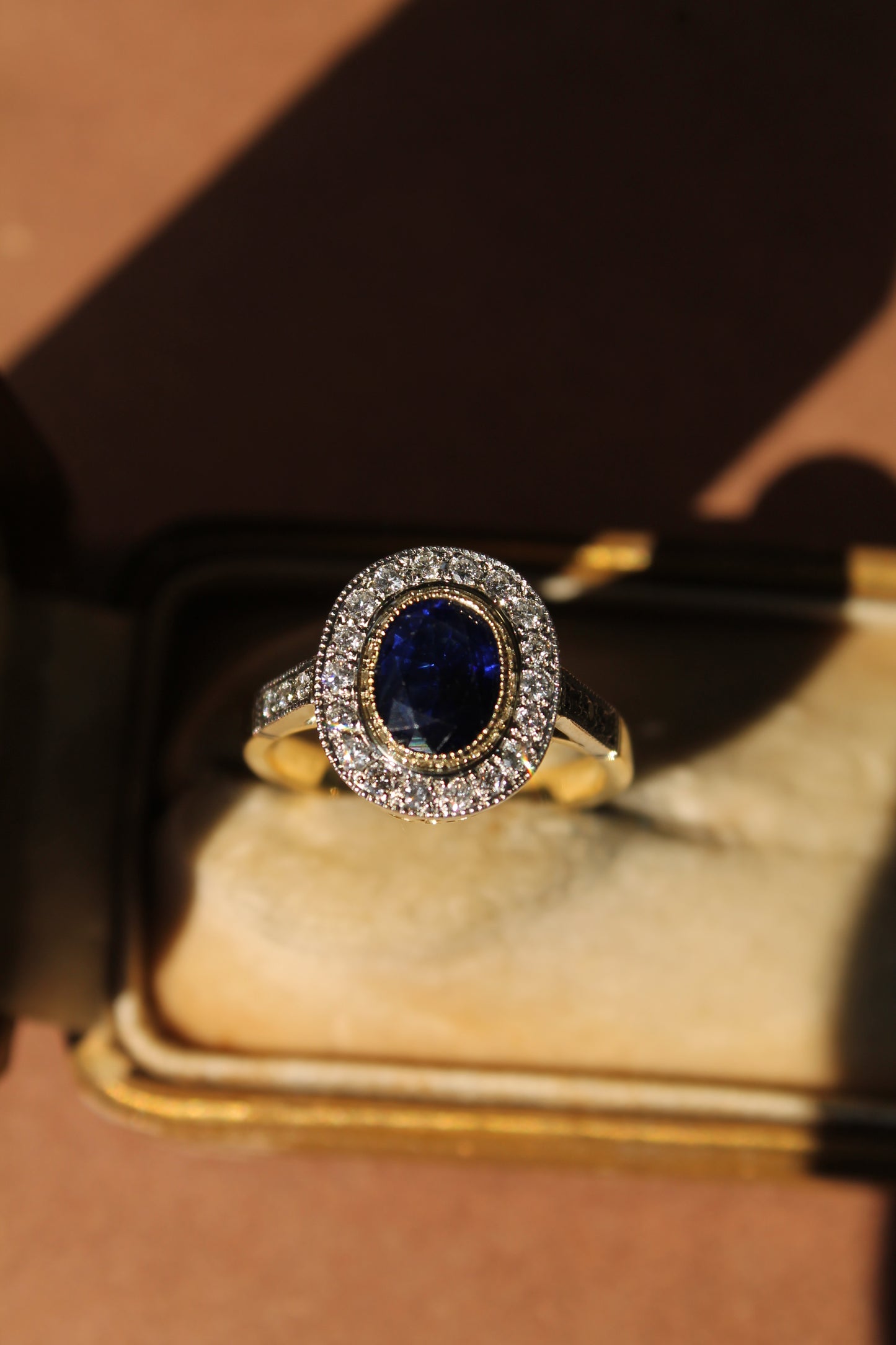 Anillo halo oval a pedido, platino, oro amarillo, zafiro y brillantes.