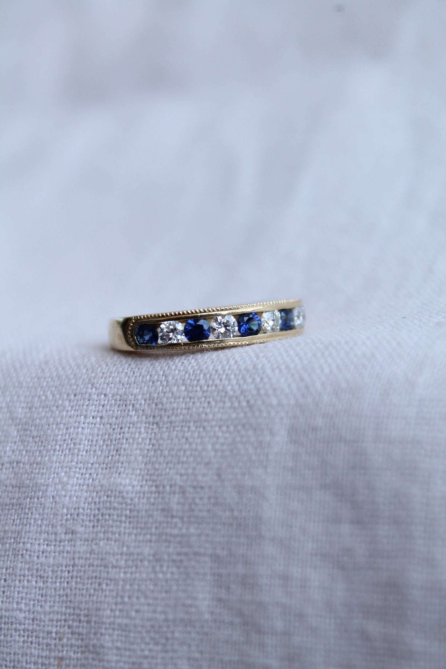 Anillo modelo medio cintillo, hecho a mano, oro amarillo, brillantes y zafiros.