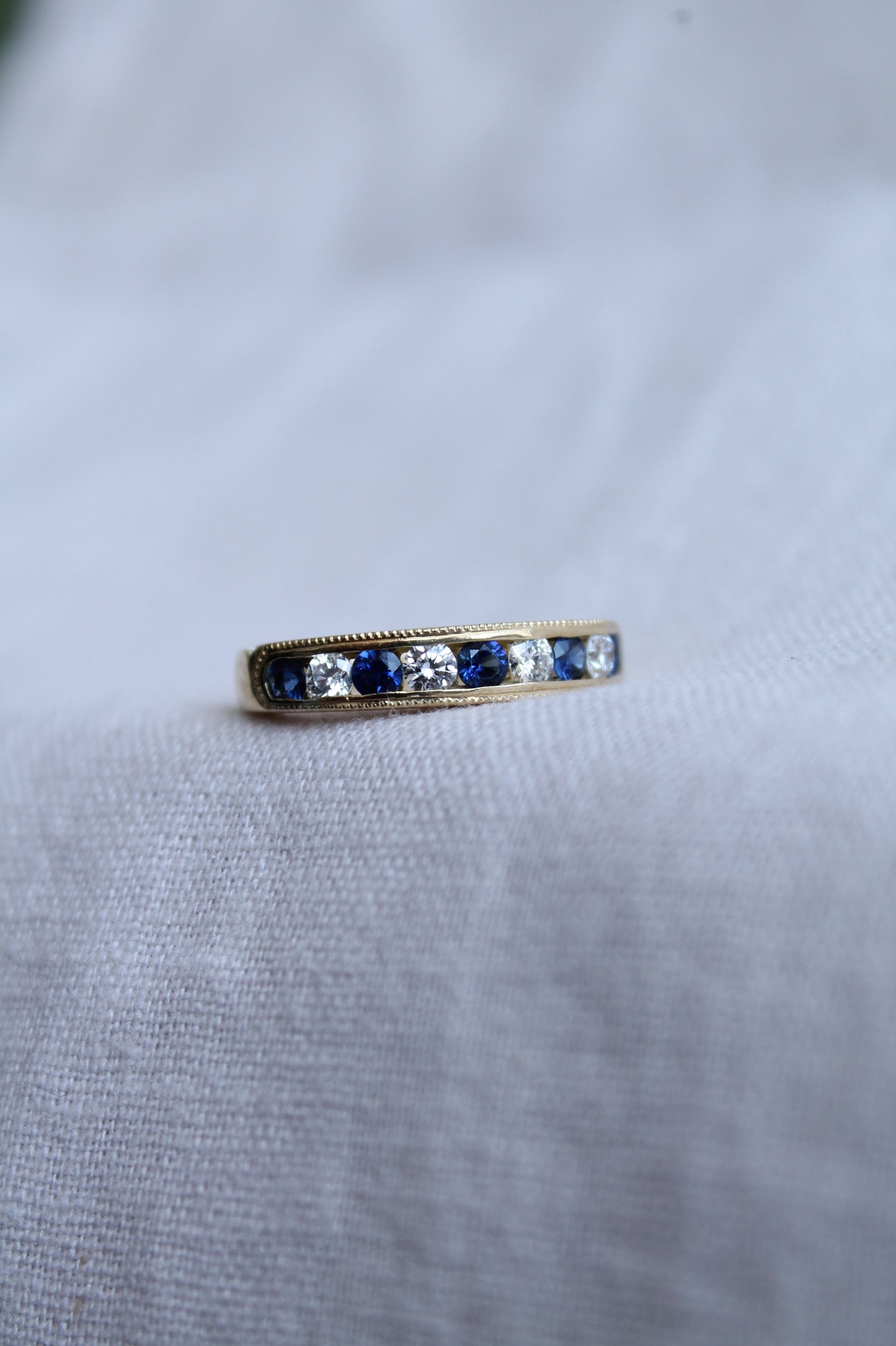 Anillo modelo medio cintillo, hecho a mano, oro amarillo, brillantes y zafiros.