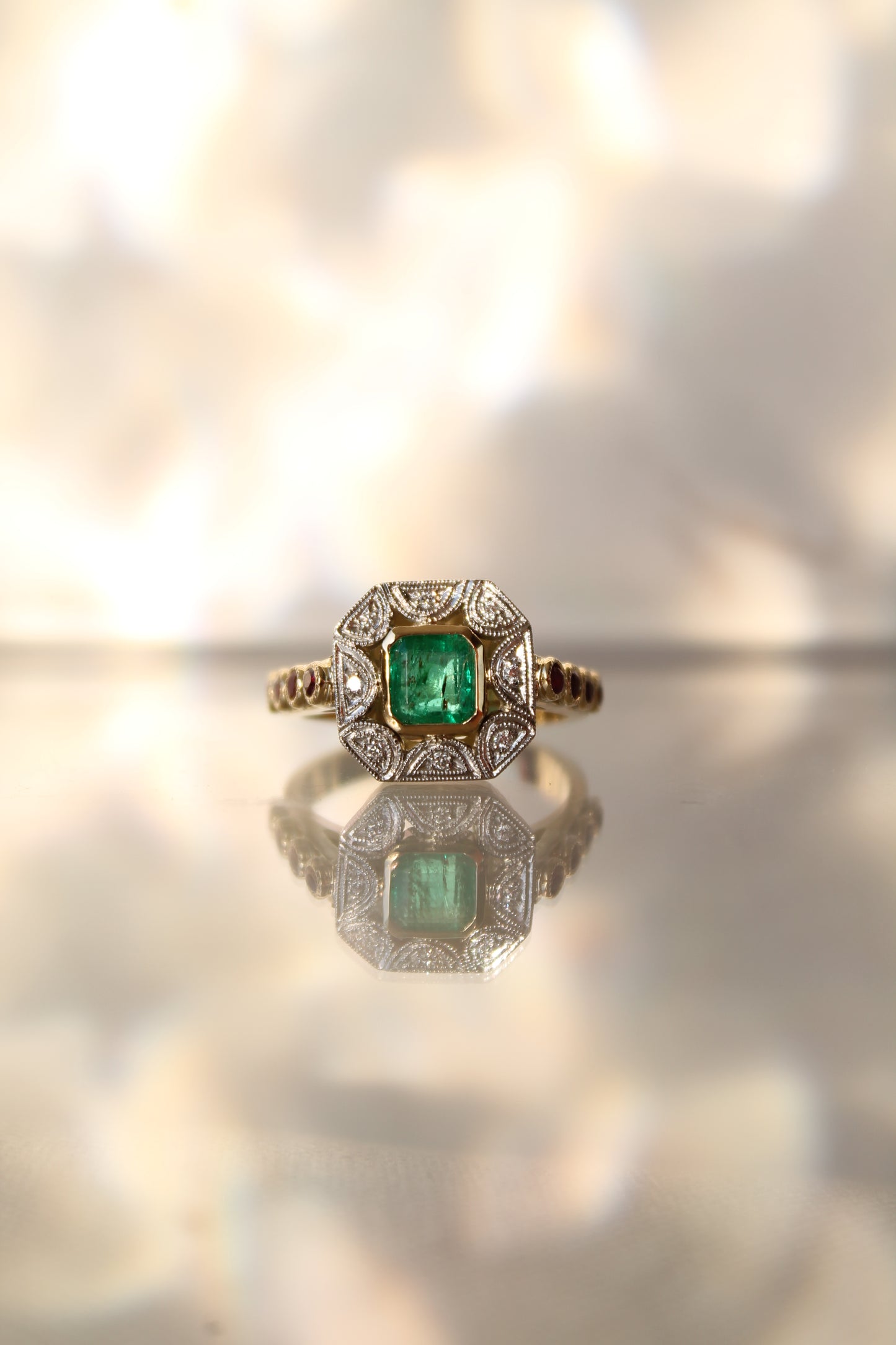 Anillo a pedido, hecho a mano, de metal platino, oro amarillo, Esmeralda, brillantes y rubíes.