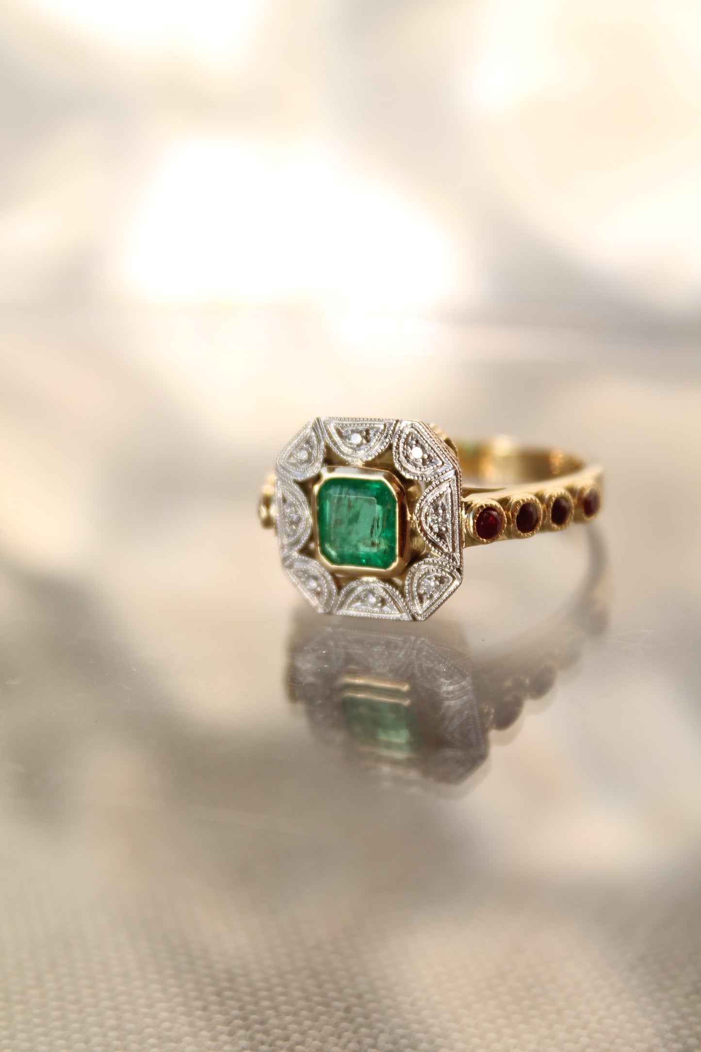 Anillo a pedido, hecho a mano, de metal platino, oro amarillo, Esmeralda, brillantes y rubíes.