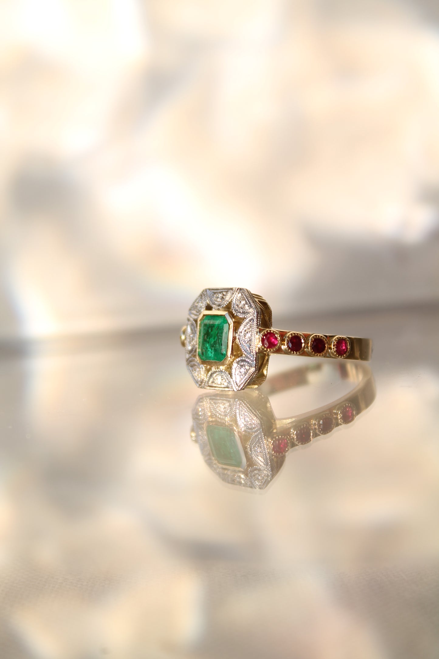 Anillo a pedido, hecho a mano, de metal platino, oro amarillo, Esmeralda, brillantes y rubíes.