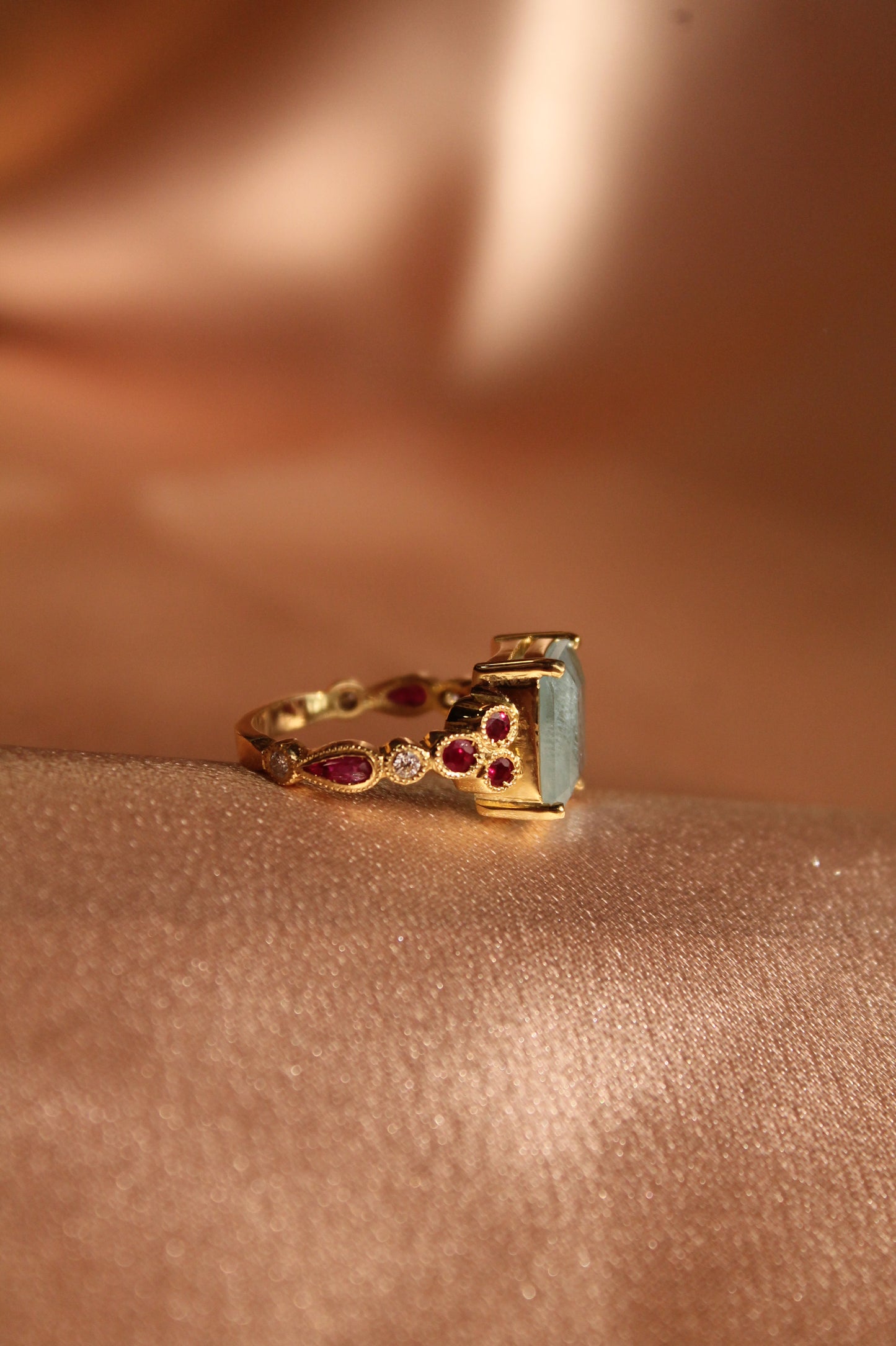 Anillo hecho a mano, mental oro amarillo, Aguamarina central, brillantes y rubíes.
