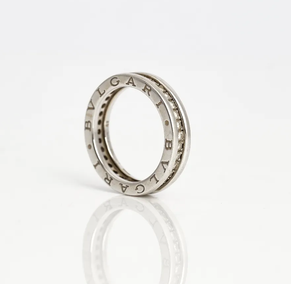 Anillo eternity, montado de diamantes por completo y oro blanco. Marca Bvlgari. En sus lados presenta dos detalles de grabado "Bvlgari".