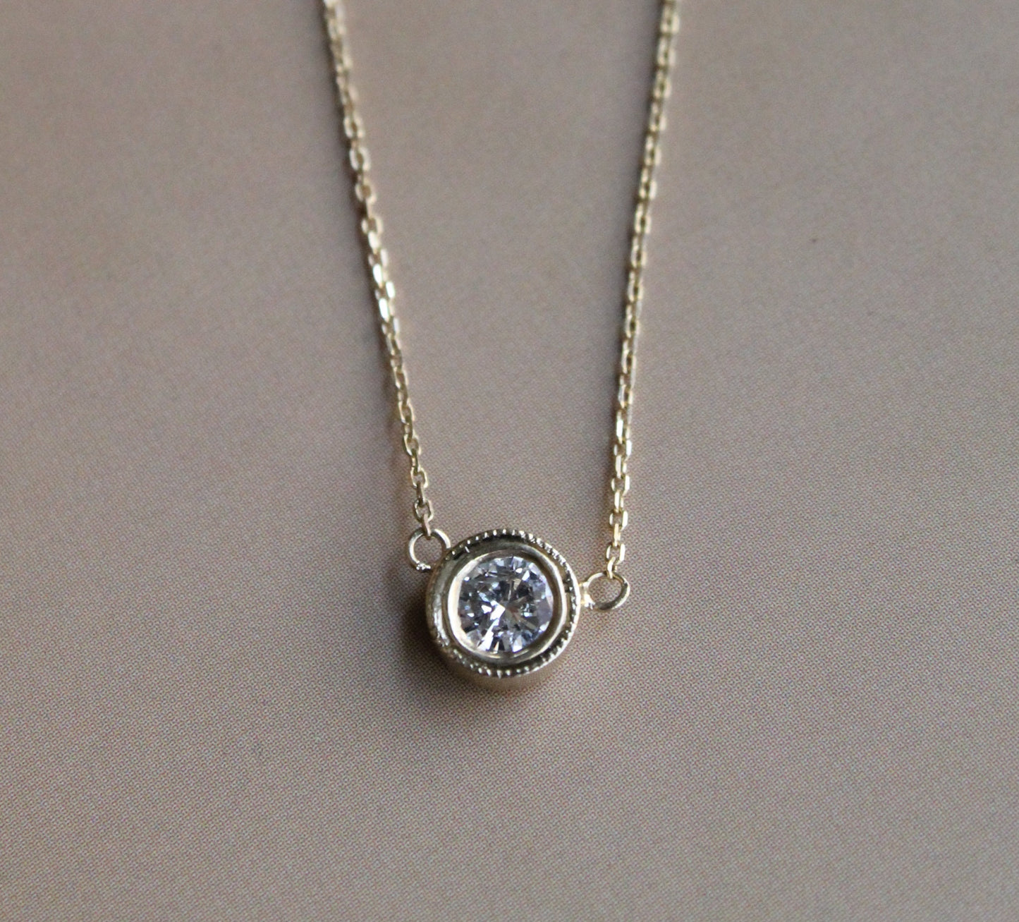 Punto de luz hecho a mano, oro amarillo 18k y brillante en bisel.