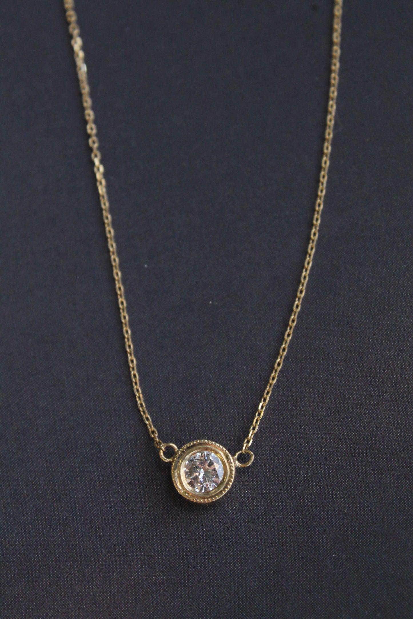 Punto de luz hecho a mano, oro amarillo 18k y brillante en bisel.
