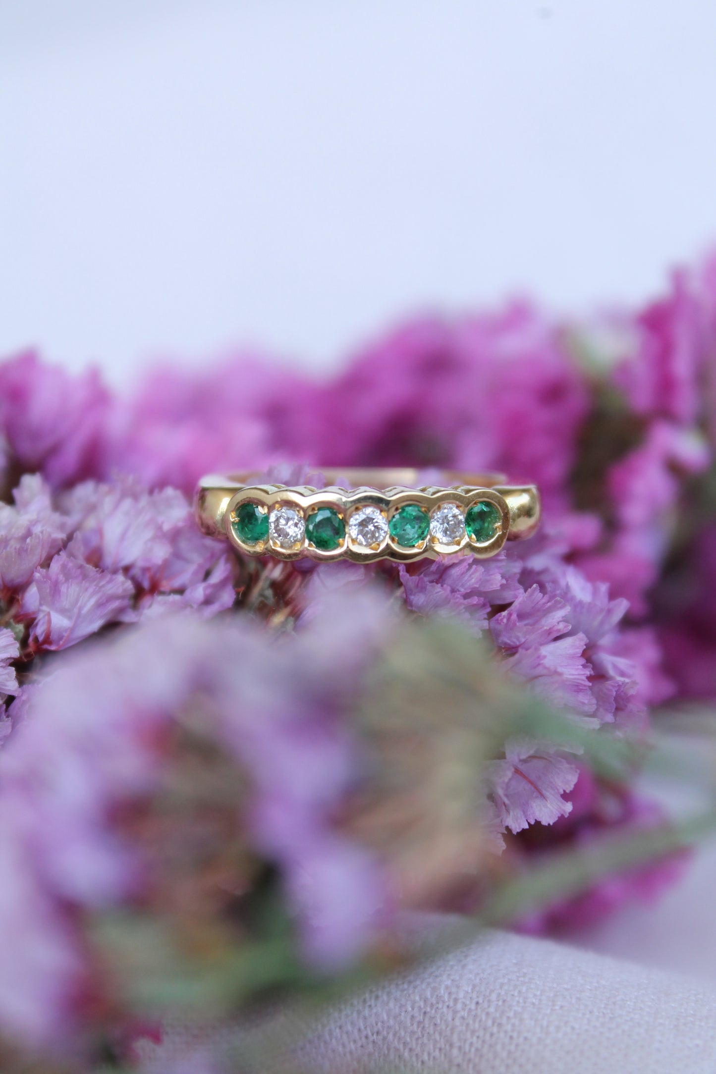 Anillo medio cintillo, hecho a mano, metal oro amarillo, brillantes y esmeraldas.