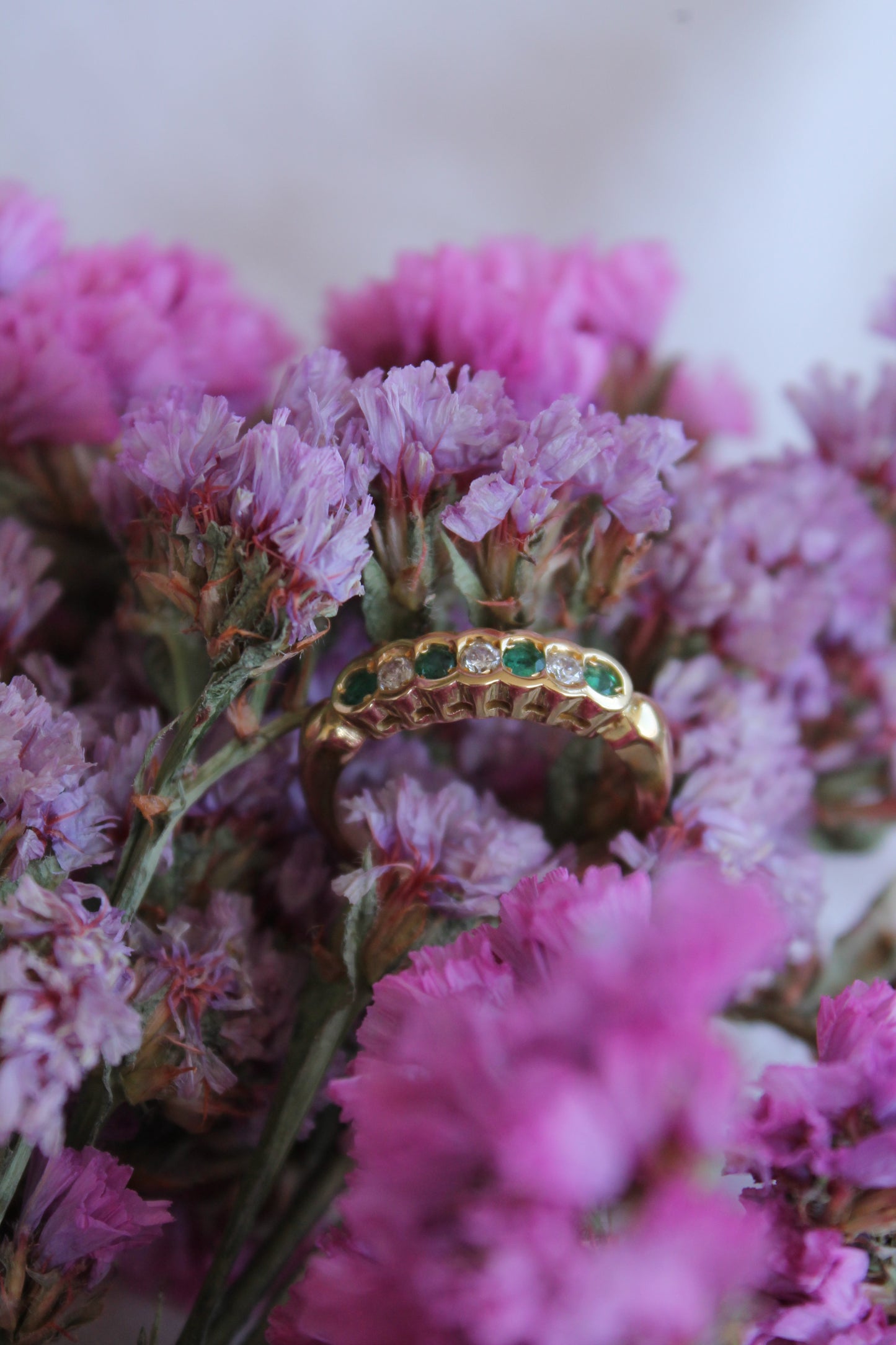 Anillo medio cintillo, hecho a mano, metal oro amarillo, brillantes y esmeraldas.