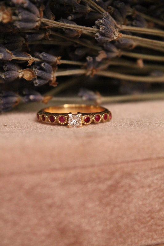 Anillo solitario europeo, oro amarillo, rubíes y diamante princesa.