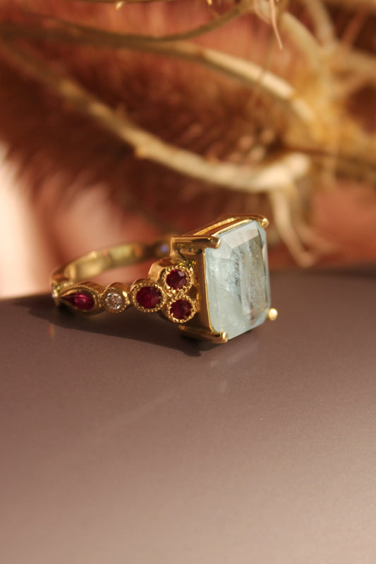 Anillo hecho a mano, mental oro amarillo, Aguamarina central, brillantes y rubíes.
